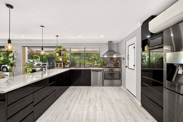 Renovated kitchen with long benchtop and stainless appliances