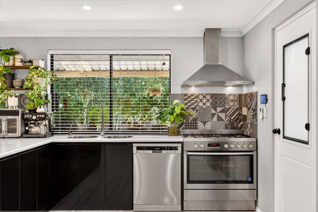 Cooking zone with rangehood and patterned splashback
